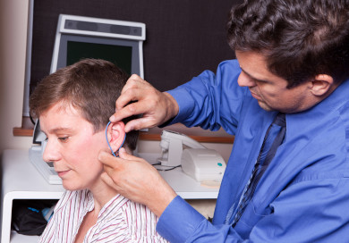 An audiologist performing real ear measurement to verify hearing aid performance